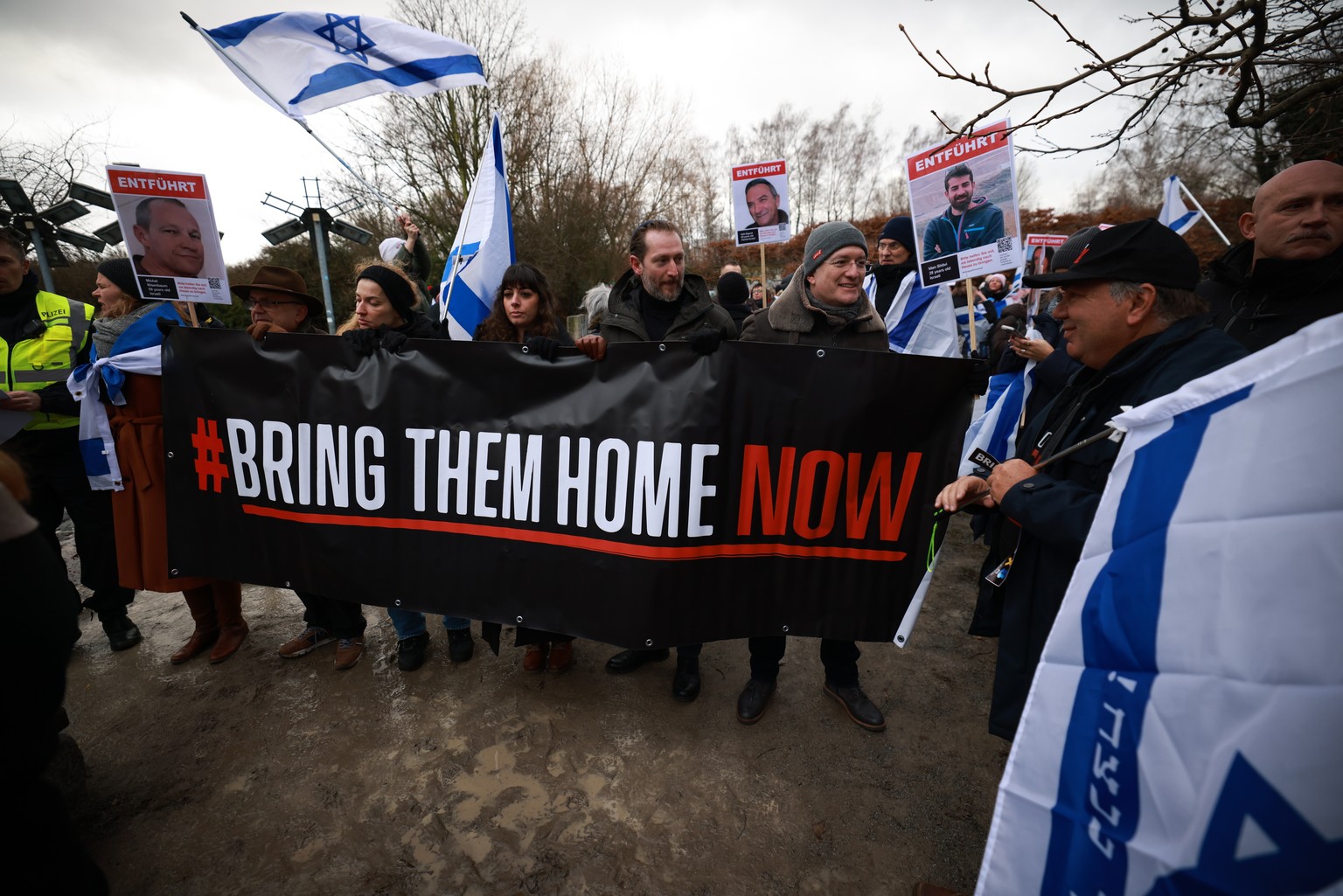 epa11076035 Participants stand with a banner reading ?# Bring Them Home Now? during a demonstration in Berlin, Germany, 14 January 2024. The demonstration took place under the motto &#039;100 days of  ...