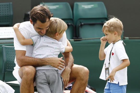 Roger Federer of Switzerland and his twin boys Leo and Lenny at the end of a training session at the All England Lawn Tennis Championships in Wimbledon, London, Thursday, June 28, 2018. The Wimbledon  ...
