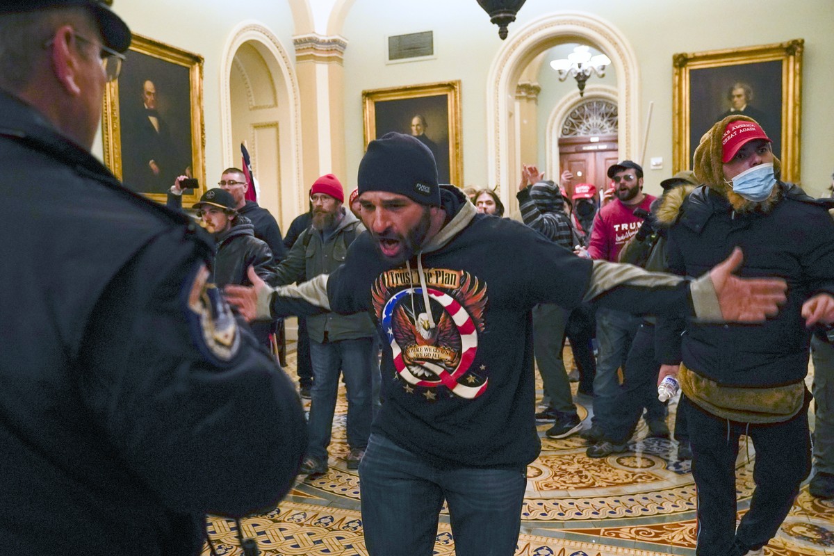 FILE - In this Jan. 6, 2021, file photo, Trump supporters, including Doug Jensen, center, confront U.S. Capitol Police in the hallway outside of the Senate chamber at the Capitol in Washington. Like m ...