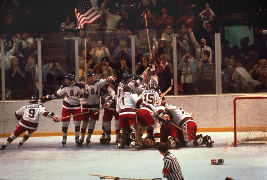 FILE -In this Feb. 22, 1980 file photo, the U.S. hockey team pounces on goalie Jim Craig after a 4-3 victory against the Soviets in the 1980 Olympics, as a flag waves from the partisan Lake Placid, N. ...