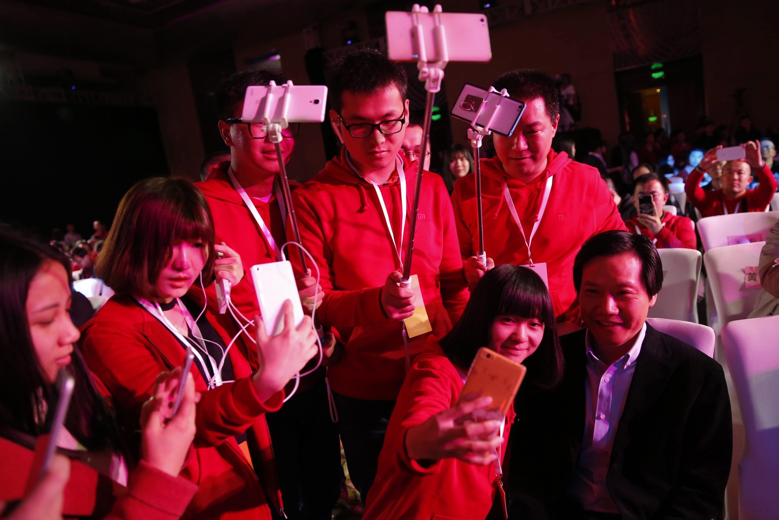 epa05226844 Fans of Xiaomi, pose and take photos with Lei Jun (R) , CEO of Chinese mobile internet company Xiaomi Technology Co. Ltd., before the Xiaomi product launch ceremony for the new Xiaomi &#03 ...