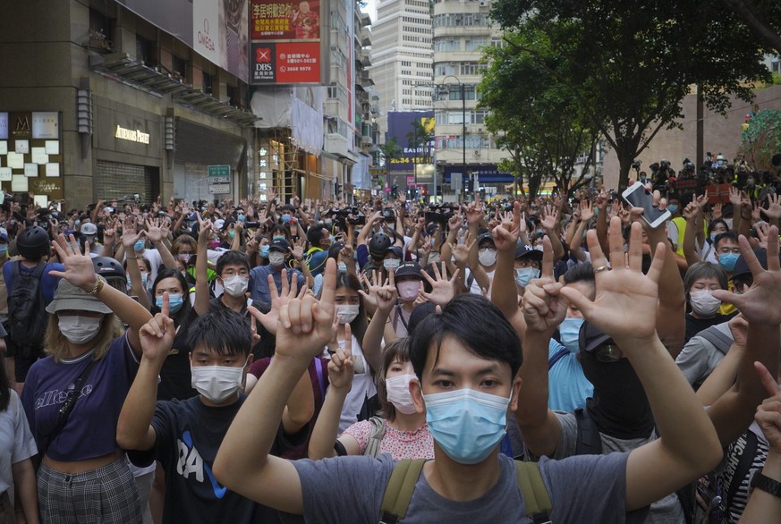 FILE - In this Wednesday, July. 1, 2020 file photo, protesters against the new national security law gesture with five fingers, signifying the &quot;Five demands - not one less&quot; on the anniversar ...