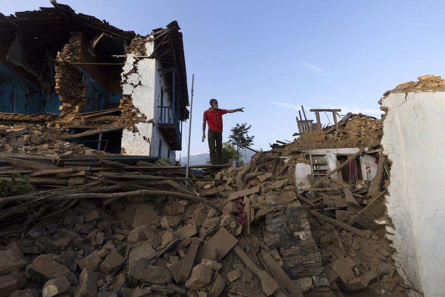 epa10959172 A man inspects a damaged house in Khalanga, a district headquarters of Jajarkot, Nepal, November 5, 2023. The death toll from the magnitude 6.4 earthquake that struck Jajarkot and West Rukum...