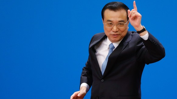 epa06615178 Chinese Premier Li Keqiang gestures at the end of a press conference after the closing of the first session of the 13th National People&#039;s Congress (NPC) at the Great Hall of the Peopl ...