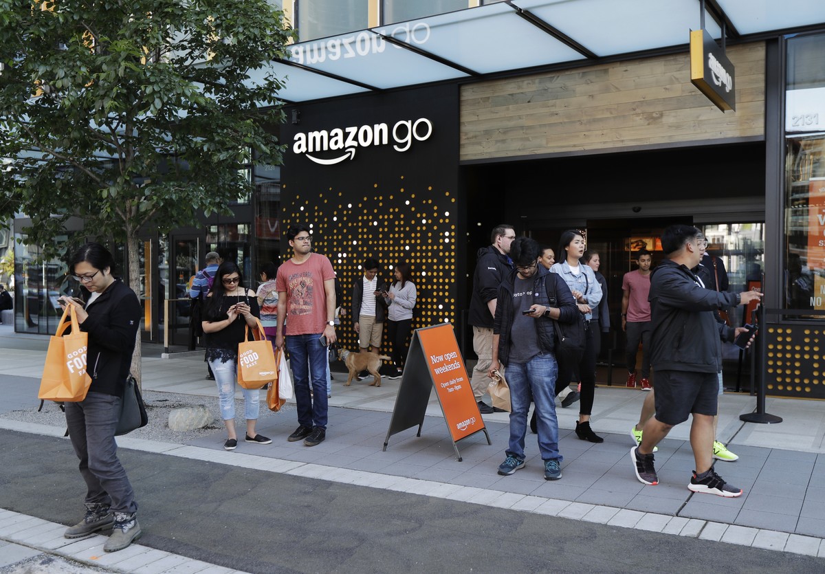 In this Monday, May 7, 2018, photo, pedestrians and cyclists gather near the Amazon Go store, in Seattle. Seattle's latest tax proposal to combat homelessness takes aim at large businesses such a ...