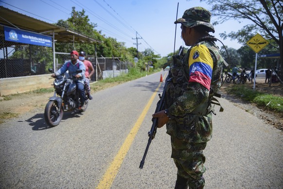 A guerrilla from the FARC-EMC stands guard on a road at a checkpoint in Corinto, Colombia, Friday, April 12, 2024, the day after a car bomb exploded in the nearby town of Miranda. President Gustavo Pe ...