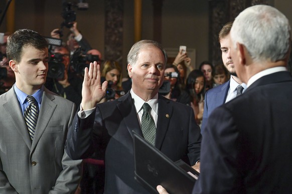 Sen. Doug Jones, D-Ala., listens as Vice President Mike Pence, right, administers the Senate oath of office during a mock swearing in ceremony in the Old Senate Chamber, Wednesday, Jan. 3, 2018, on Ca ...