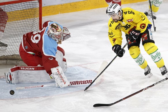 Lausanne&#039;s goaltender Cristobal Huet, of France, left, saves a puck past Bern&#039;s center Mark Arcobello, of U.S.A., right, during a National League regular season game of the Swiss Championshi ...