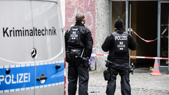 epa08904702 Policemen stand in front a door of a residential building showing a bullet hole during investigations at the crime scene in Berlin, Germany, 26 December 2020. Media reports state, that fou ...