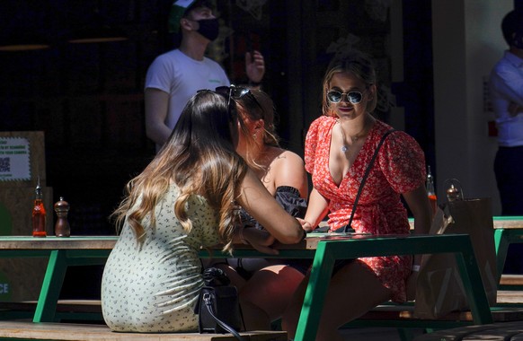 People sit at outdoor tables of a restaurant in Carnaby Street, in London, Monday, June 14, 2021. British Prime Minister Boris Johnson is expected to confirm Monday that the next planned relaxation of ...