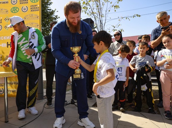GROZNY, CHECHEN REPUBLIC, RUSSIA - SEPTEMBER 17, 2022: Valid Edilov (L), Minister of Sports and Physical Culture of the Chechen Republic, awards the winner of the 2022 Cross of the Nation mass race.  More...