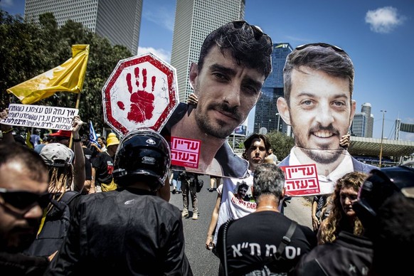 Israel nationwide protests and a general strike An Israeli protestor holds up cardboard cuttings of Ariel, L, And David, Cunio during a demonstration in Tel Aviv, Sunday Aug 17 2025, calling on Israel ...