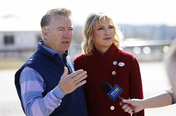 Sen. Rand Paul, R-Ky, left, answers questions from reporters after voting with his wife Kelley at Cumberland Trace Elementary School in Bowling Green, Ky., Tuesday, Nov. 8, 2022. (AP Photo/Michael Clu ...