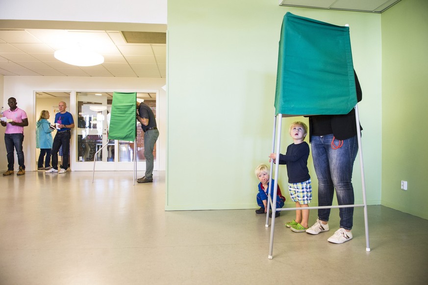 A woman casts her vote behind behind a screen at a polling station during the Swedish general election in Stockholm September 14, 2014. Polls showed Sweden&#039;s center-left opposition heading for a  ...