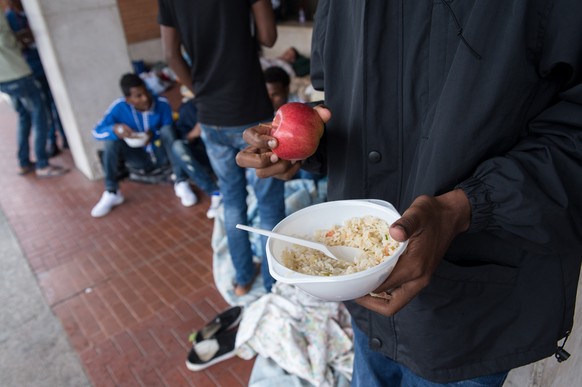 Fluechtlinge erhalten eine Mahlzeit von Freiwilligen der Tessiner Hilfsgruppe Associazione Firdaus, am Freitag, 5. August 2016, am Bahnhof in Como, Italien. Derzeit befinden sich in Como viele Fluecht ...