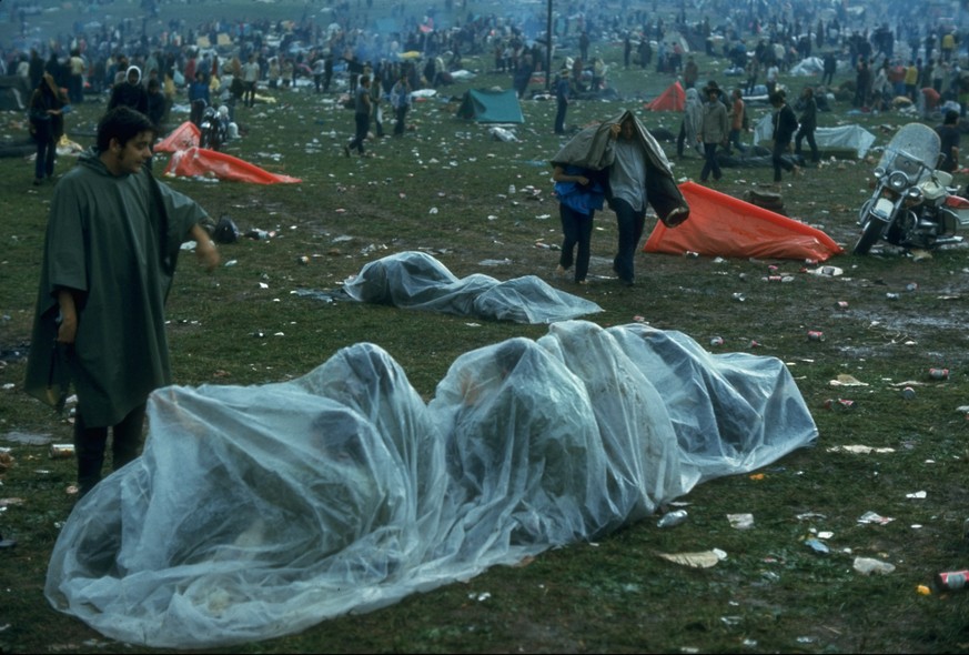 NEW YORK, UNITED STATES - AUGUST 1969: Several youths huddled together under a piece of clear plastic in the rain during the Woodstock Music &amp; Art Fair. (Photo by John Dominis/The LIFE Picture Col ...