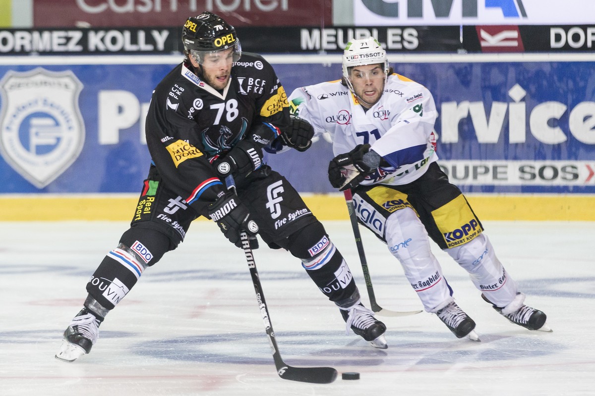 L'attaquant fribourgeois Marc-Antoine Pouliot, gauche, lutte pour le puck avec l'attaquant biennois Julian Schmutz, droite, lors de la rencontre du championnat suisse de hockey sur glace de  ...