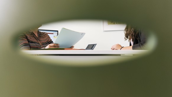 ARCHIVBILD ZU DEN ZAHLEN ZUR SOZIALHILFE 2016 --- A consultation meeting photographed through the back of a chair in an office of the social center Albisriederhaus on Albisriederstrasse in Zurich, Swi ...