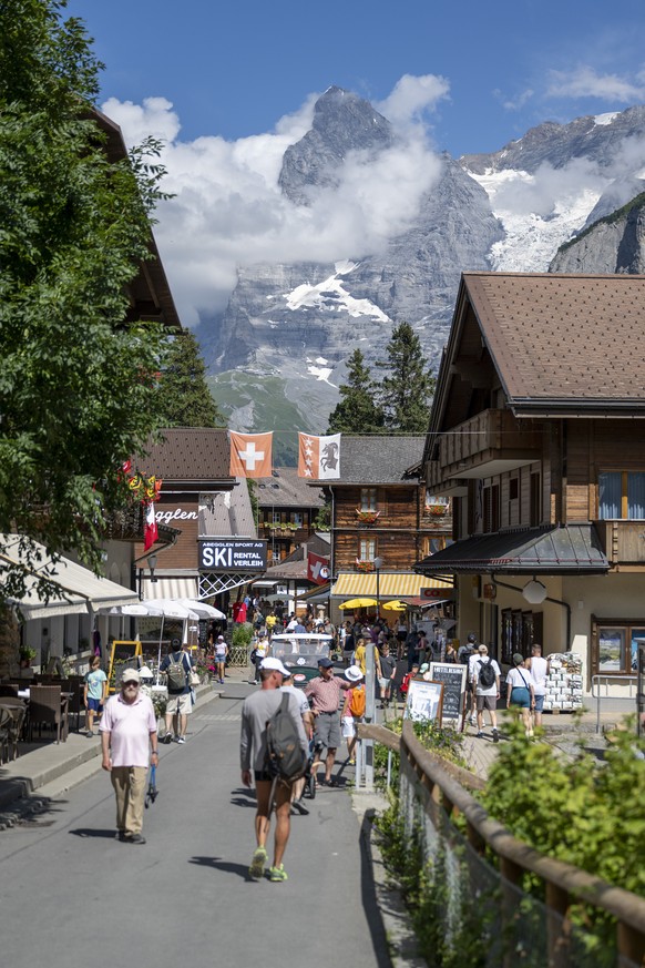 Toristen spazieren im Dorf mit dem Eiger im Hintertgrund, am Freitag, 9. August 2024, in Muerren..(KEYSTONE/Peter Schneider)