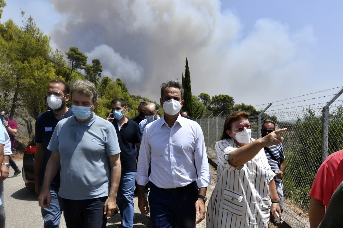 Greece's Prime Minister Kyriakos Mitsotakis, center, accompanied by Culture Minister Lina Mendoni, right, and Minister for Citizen Protection Michalis Chrisochoidis, left, visit the ancient Olymp ...