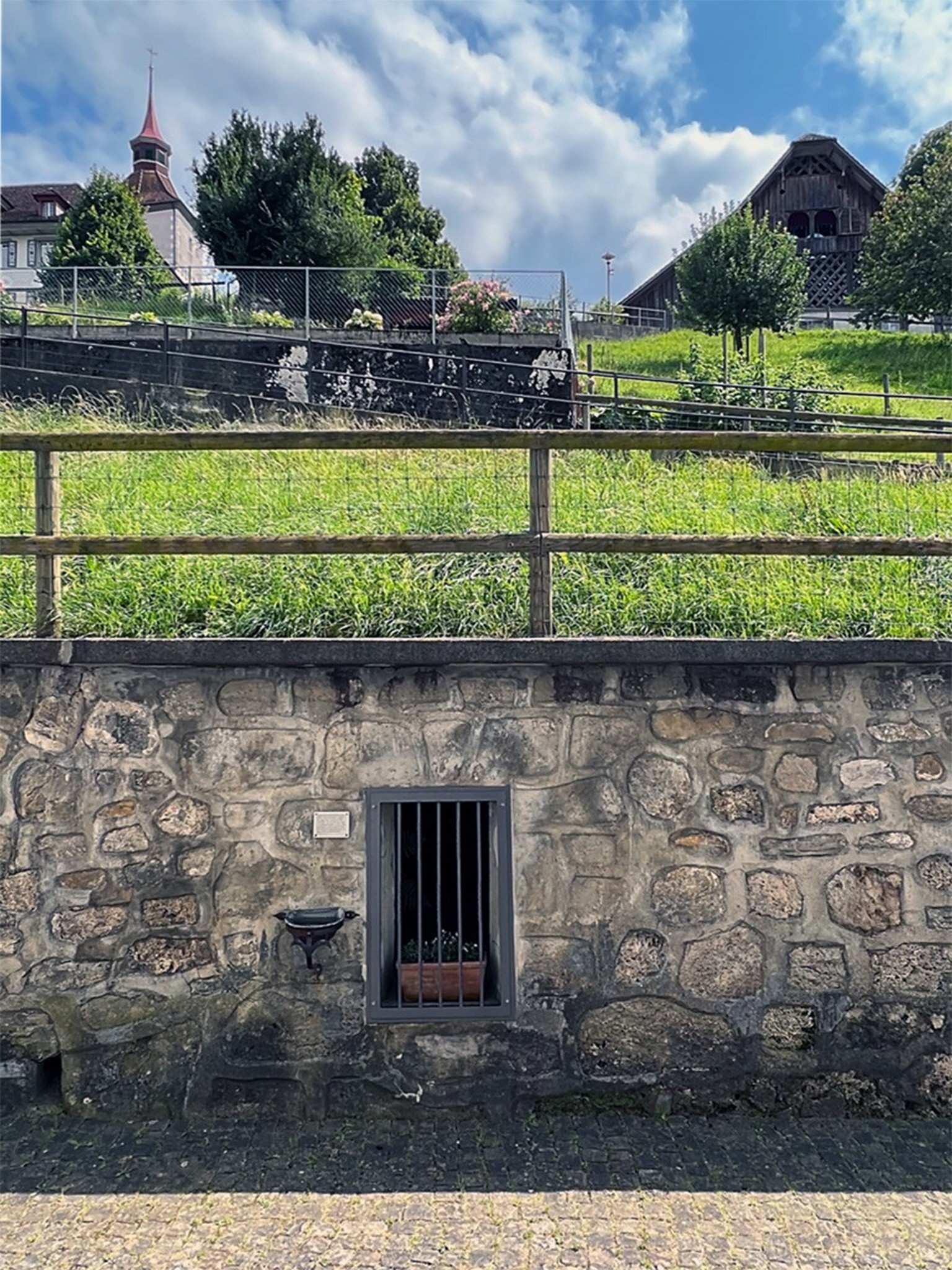 Pfarrkirche Willisau, Schlossrain. Das «eiserne Türi» führt durch die Friedhofmauer zum dahinter liegenden «Chilelöchli» – ausserhalb der geweihten Erde. Um 1970 wird eine kleine Tafel angebracht: «La ...