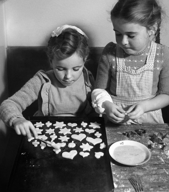 SCHWEIZ WEIHNACHTEN
--- AUS DER ORIGINALLEGENDE DER WEIHNACHTSSERIE, AUFGENOMMEN IM DEZEMBER 1950 --- &quot;Wir backen Weihnachtsguetzli - Wer hilft mit? Doch die Mutter haette gar nicht zu fragen bra ...