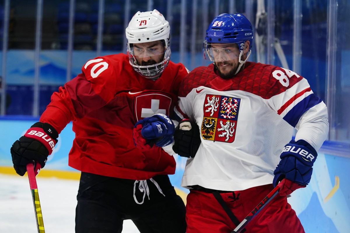 Switzerland's Denis Hollenstein (70) and Czech Republic's Tomas Kundratek (84) lock arms during a men's qualification round hockey game at the 2022 Winter Olympics, Tuesday, Feb. 15, 20 ...