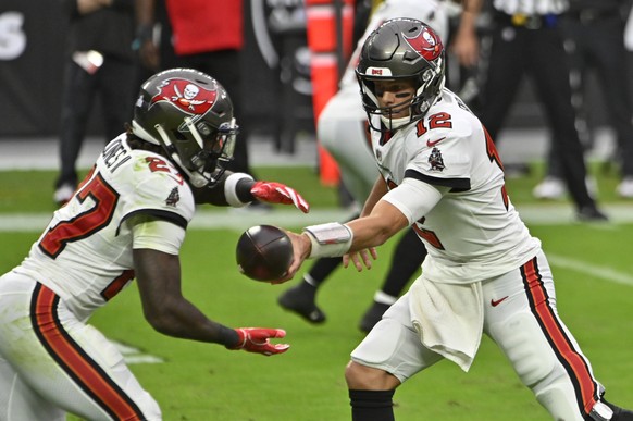 Tampa Bay Buccaneers quarterback Tom Brady (12) hands off the ball to running back Ronald Jones (27) during the first half of an NFL football game against the Las Vegas Raiders, Sunday, Oct. 25, 2020, ...