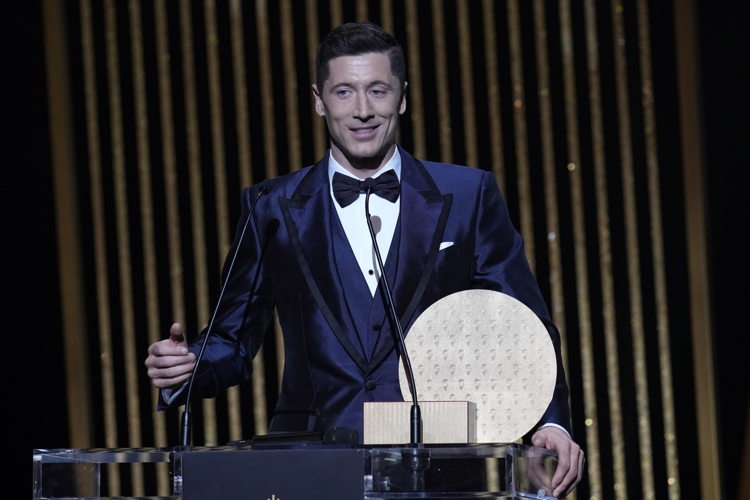 Bayern Munich Robert Lewandowski holds the 2021 Ballon d&#039;Or trophy for striker of the year during the 65th Ballon d&#039;Or ceremony at Theatre du Chatelet, in Paris, Monday, Nov. 29, 2021. (AP P ...