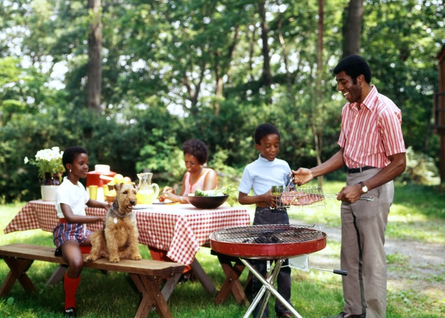 1970s AFRICAN AMERICAN FAMILY BACKYARD PICNIC BARBECUE (Photo by Photo Media/ClassicStock/Getty Images)