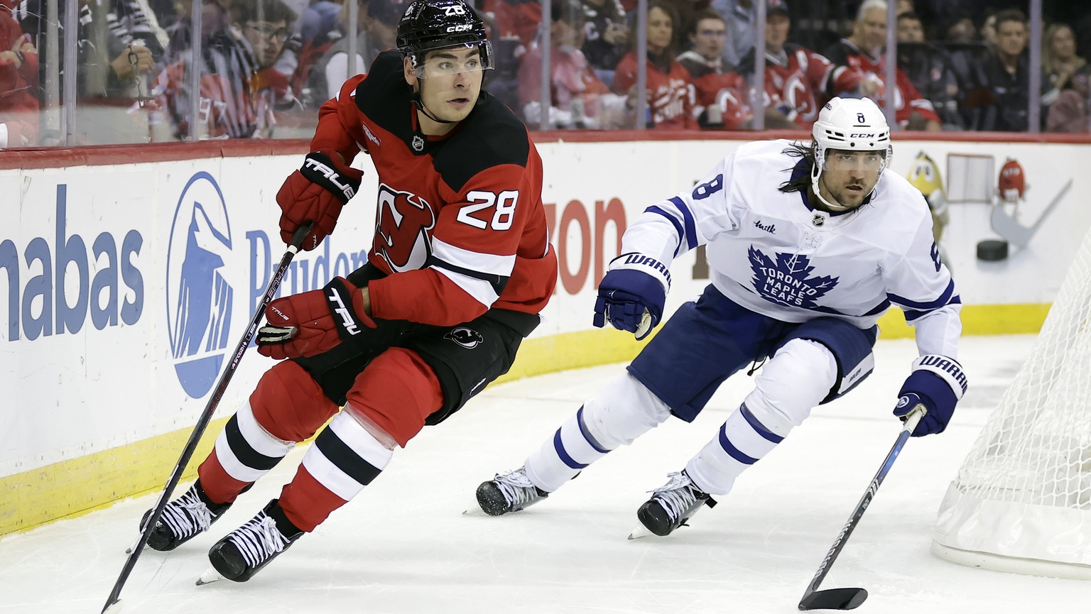 New Jersey Devils right wing Timo Meier (28) controls the puck past Toronto Maple Leafs defenseman Chris Tanev (8) during the second period of an NHL hockey game Thursday, Oct. 10, 2024, in Newark, N. ...
