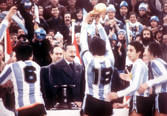 Argentine President Jorge Rafael Videla (centre) after he had presented the World Cup Trophy to Argentine's captain Daniel Passarella (No 19), at the presentation ceremony in the River Plate Stad ...