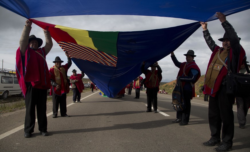 Aymaras hold a portion of the Bolivian naval flag on the highway between Oruro and La Paz Bolivia, Saturday, March 10, 2018. A narrow strip of blue stretched for more than 150 miles (nearly 200 kilome ...