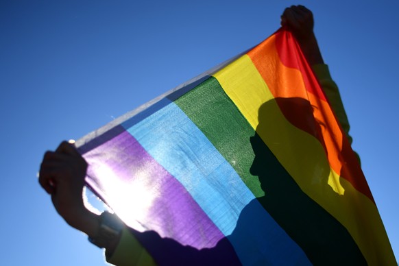 epa06131298 Marriage equality advocate Russell Nankervis poses for a photograph with a rainbow flag during the &#039;Sea of Hearts&#039; event supporting Marriage Equality outside Parliament House in  ...