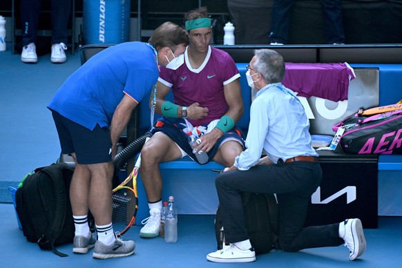 epa09707483 Rafael Nadal of Spain is attended to during a medical time out in his quarter final match against Denis Shapovalov of Canada at the Australian Open Grand Slam tennis tournament at Melbourne Park, in Melbourne, Australia, 25 January 2022. EPA/DEAN LEWINS AUSTRALIA AND NEW ZEALAND OUT