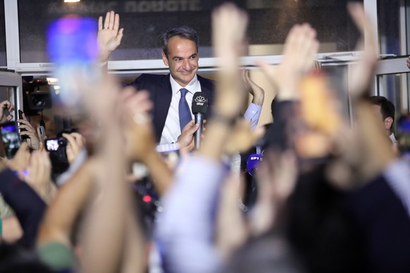 epa10644762 Greek Prime Minister and leader of New Democracy political party, Kyriakos Mitsotakis, greets supporters after the announcement of the first results of the Greek general elections, at the  ...