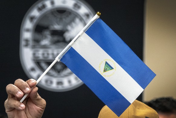 epa10468830 Nicaraguan ex-prisoner Victor Manuel Sosa Herrera holds an inverted Nicaragua flag during a press conference at the Stephen P. Clark Government Center in Miami, Florida, USA, 15 February 2 ...
