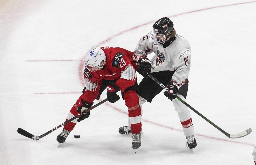 Switzerland&#039;s Cedric Fiedler (23) and Austria&#039;s Finn van Ee (26) battle for the puck during second period IIHF World Junior Hockey Championship pre-competition action in Edmonton, Alberta, o ...