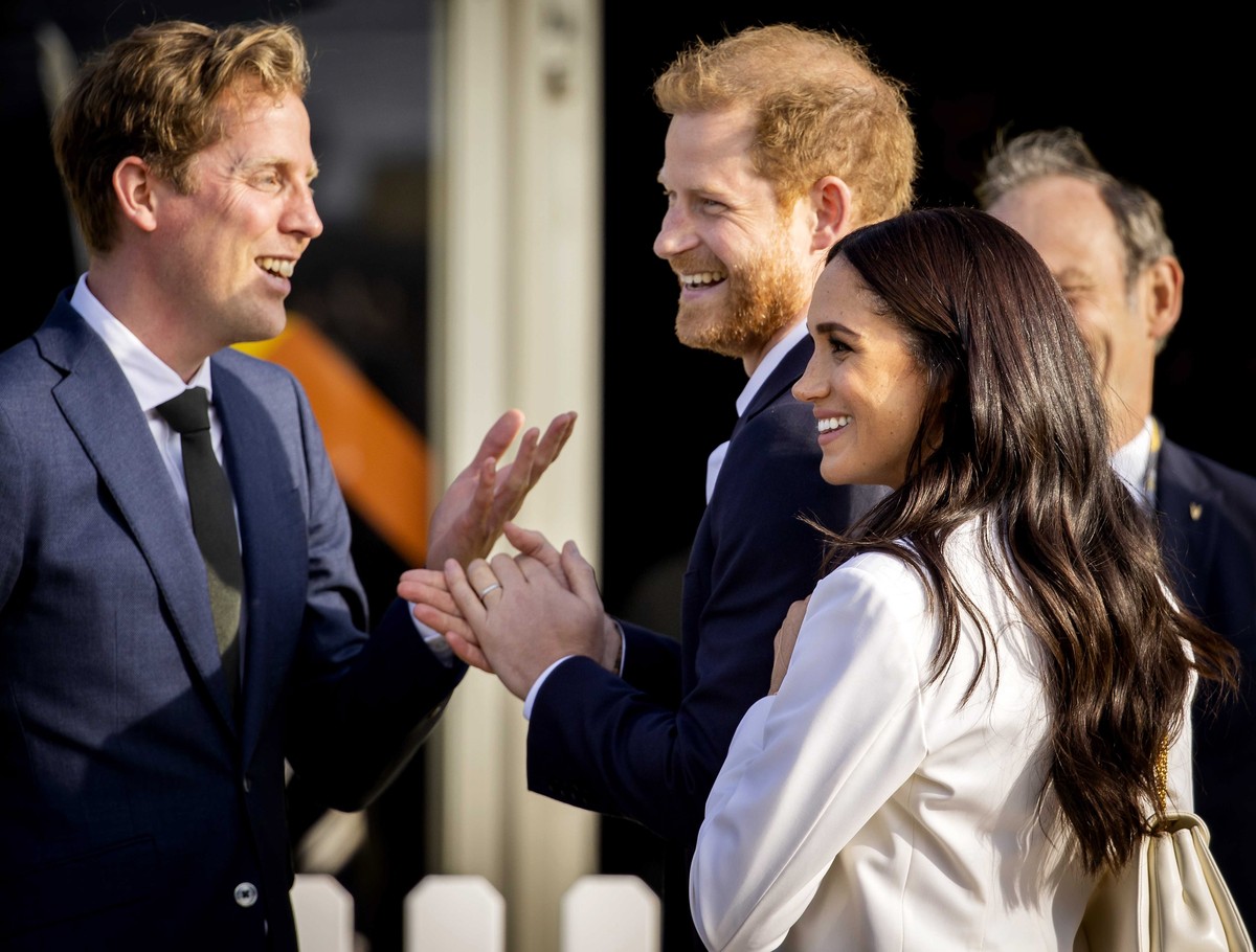 epa09891711 Britain's Prince Harry, Duke of Sussex (C) and his wife, Meghan, Duchess of Sussex (R) arrive on the Yellow Carpet before the start of the Invictus Games in The Hague, The Netherlands ...