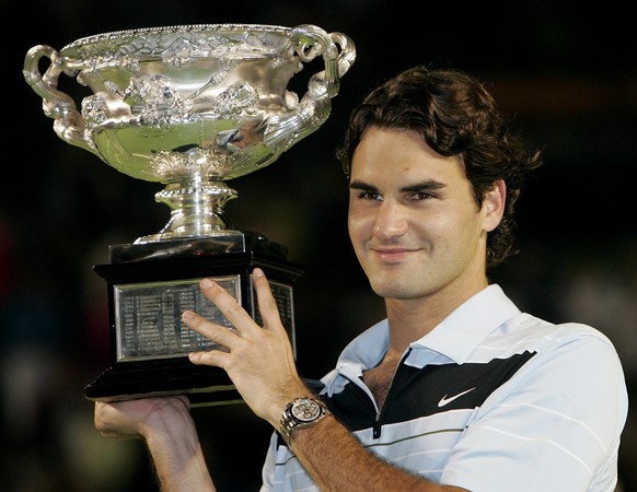 Switzerland&#039;s Roger Federer holds his trophy aloft after winning the men&#039;s singles final against Chile&#039;s Fernando Gonzalez at the Australian Open tennis tournament in Melbourne, Austral ...