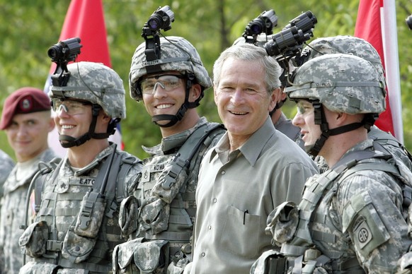 FILE - President George W. Bush smiles as he poses for a group photo with military personnel during his visit to U.S. Army Special Operations Command at Fort Bragg, N.C., July 4, 2006. (AP Photo/Pablo ...