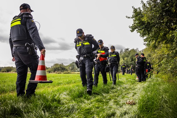 epa13206382 Members of a mobile police unit search a field in Nederasselt, a day after a shooting in neighbouring Overasselt, Gelderland province, the Netherlands, 02 September 2026. The shooting left ...
