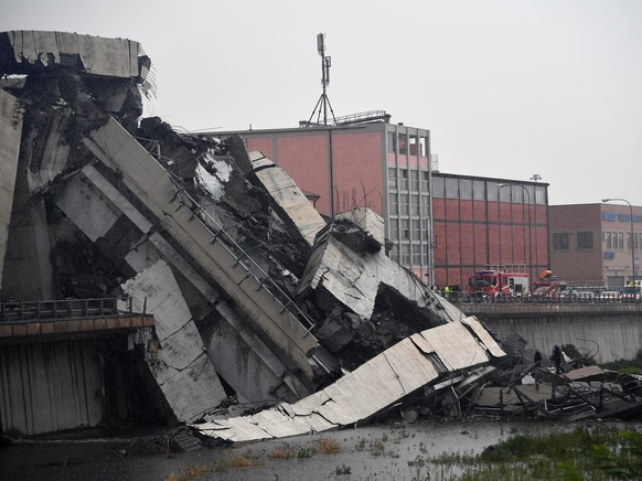 epa06948817 A large section of the Morandi viaduct upon which the A10 motorway runs collapsed in Genoa, Italy, 14 August 2018. Both sides of the highway fell. Around 10 vehicles are involved in the co ...