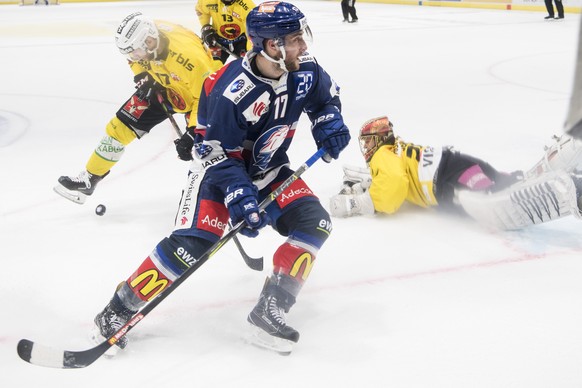 Zuercher Drew Shore, Mitte, kaempft um den Puck gegen Berns Gian-Andrea Randegger, links, im zweiten Eishockey Playoff-Halbfinalspiel der National League zwischen den ZSC Lions und dem SC Bern am Donn ...