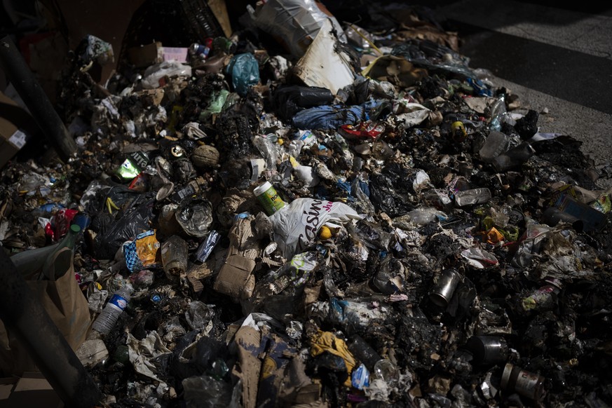 Burnt trash is pictured on a street corner after an eight-day-long garbage collectors strike in Marseille, southern France, Wednesday, Oct. 6, 2021. (AP Photo/Daniel Cole)