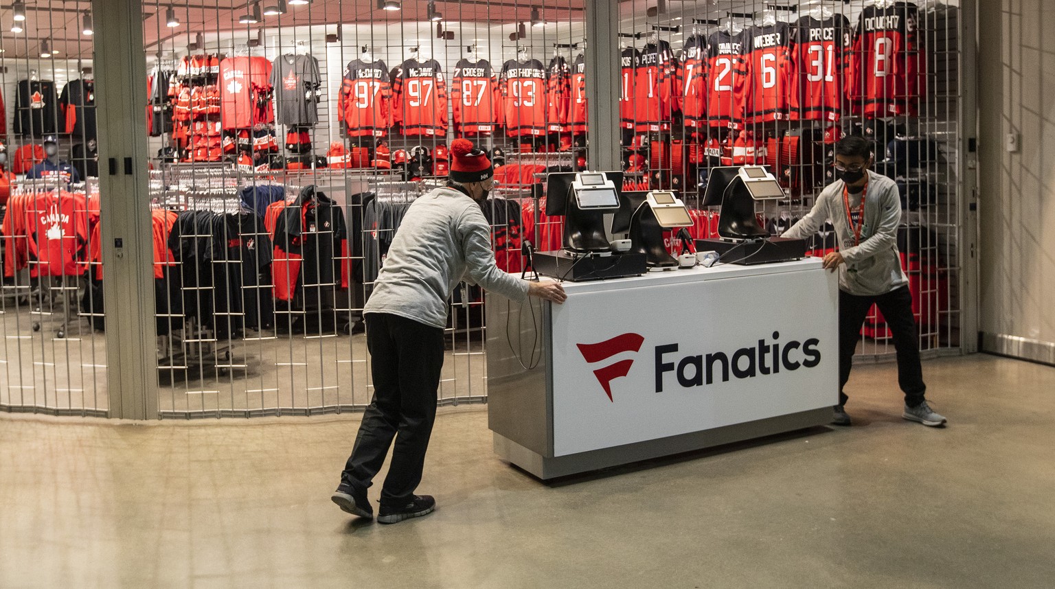 Employees close up a Team Canada merchandise store after the remainder of the IIHF World Junior Hockey Championship was cancelled, Wednesday, Dec. 29, 2021, in in Edmonton, Alberta. (Jason Franson/The ...