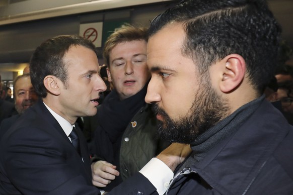 epa06906476 French president Emmanuel Macron (L) greets supporters, as the Elysee senior security officer Alexandre Benalla (R) looks on during a visit at the 55th International Agriculture Fair (Salo ...