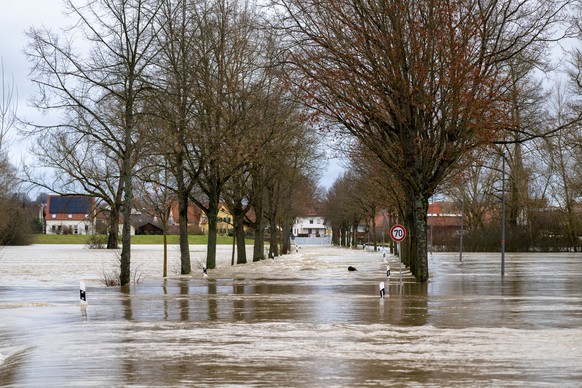 25.12.2023, Bayern, Ebing: Eine Stra�e bei Ebing (Landkreis Bamberg) steht unter Wasser. Der Main f�hrt Hochwasser. Die Hochwasserlage in Bayern hat sich etwas beruhigt. Der Hochwassernachrichtendiens ...