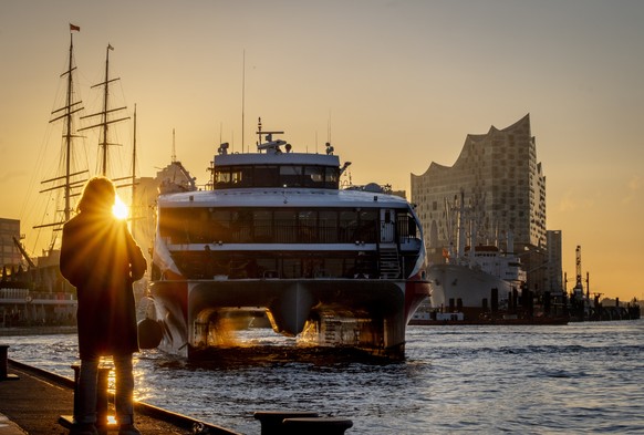 The catamaran ferry going to the island of Helgoland arrives in the harbour as the sun rises in Hamburg, Germany, Friday, Oct. 4, 2024. (AP Photo/Michael Probst)