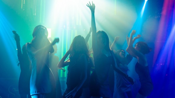 Silhouette Bild von Menschen tanzen in Disco Nachtclub zu Musik von DJ auf der Bühne . Neue Jahr Nacht Party und Nachtleben Konzept .
